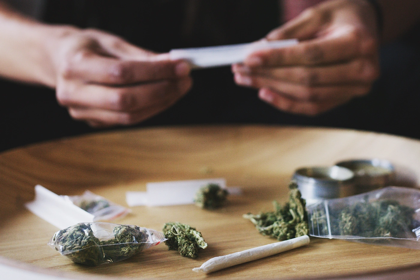 Homme qui roule un joint avec du CBD posé sur une table