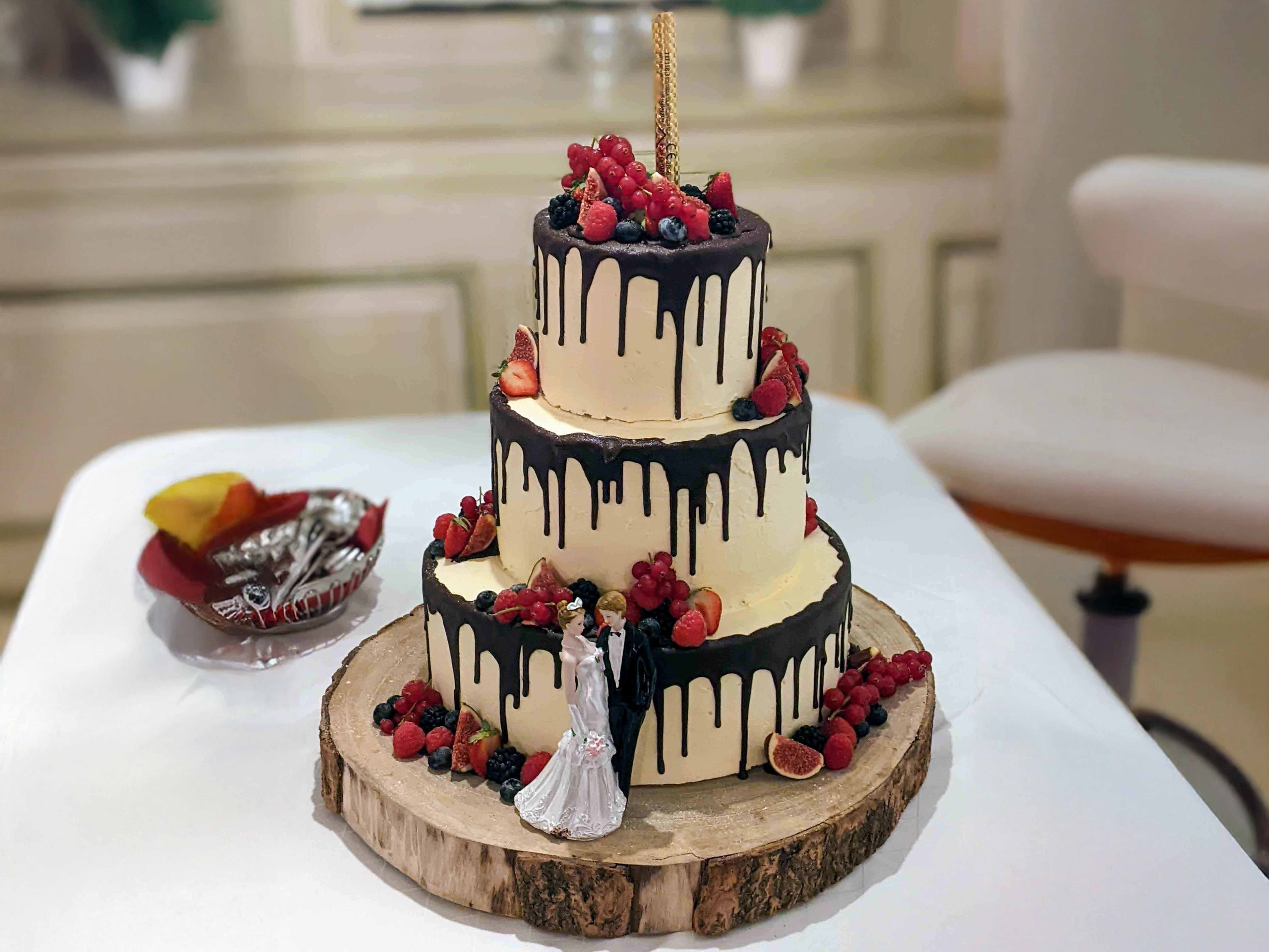 Hochzeitstorte mit Erdbeeren und Dunkler Glasur am Rand der einzelnen Ebenen