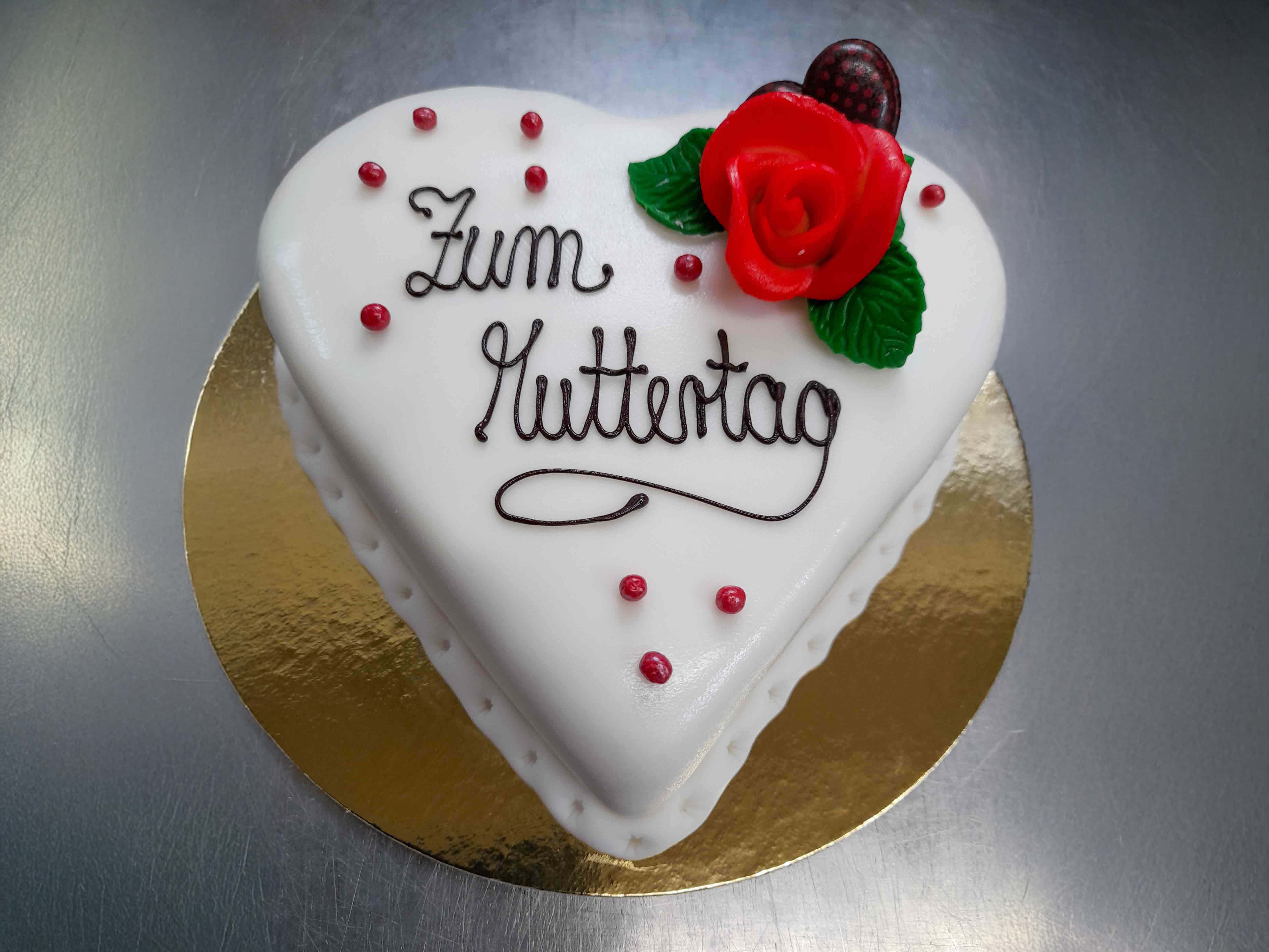 Weiße Muttertagstorte in Herzform mit Rosen Dekoration