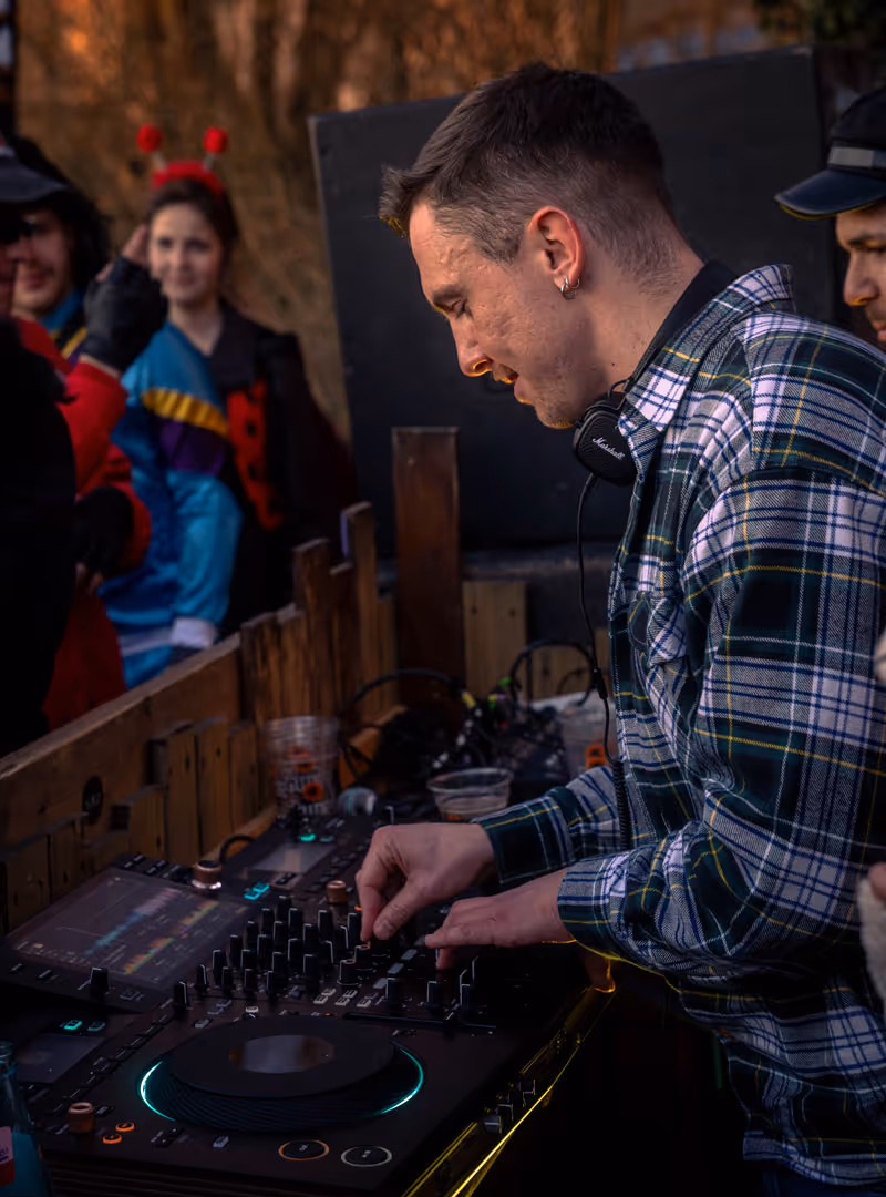 DJ legt auf beim Strive-Studio Fastnacht-Event – verkleidete Gäste tanzen im Hintergrund