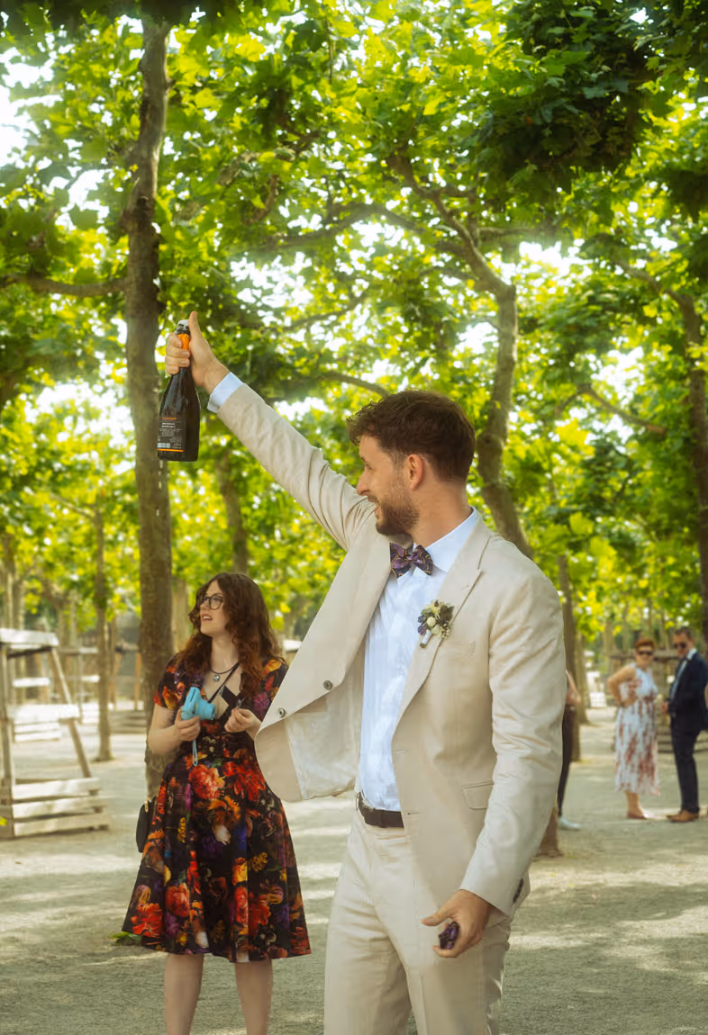 Magnus stößt mit Sekt im Freien auf die Hochzeit mit Gästen an
