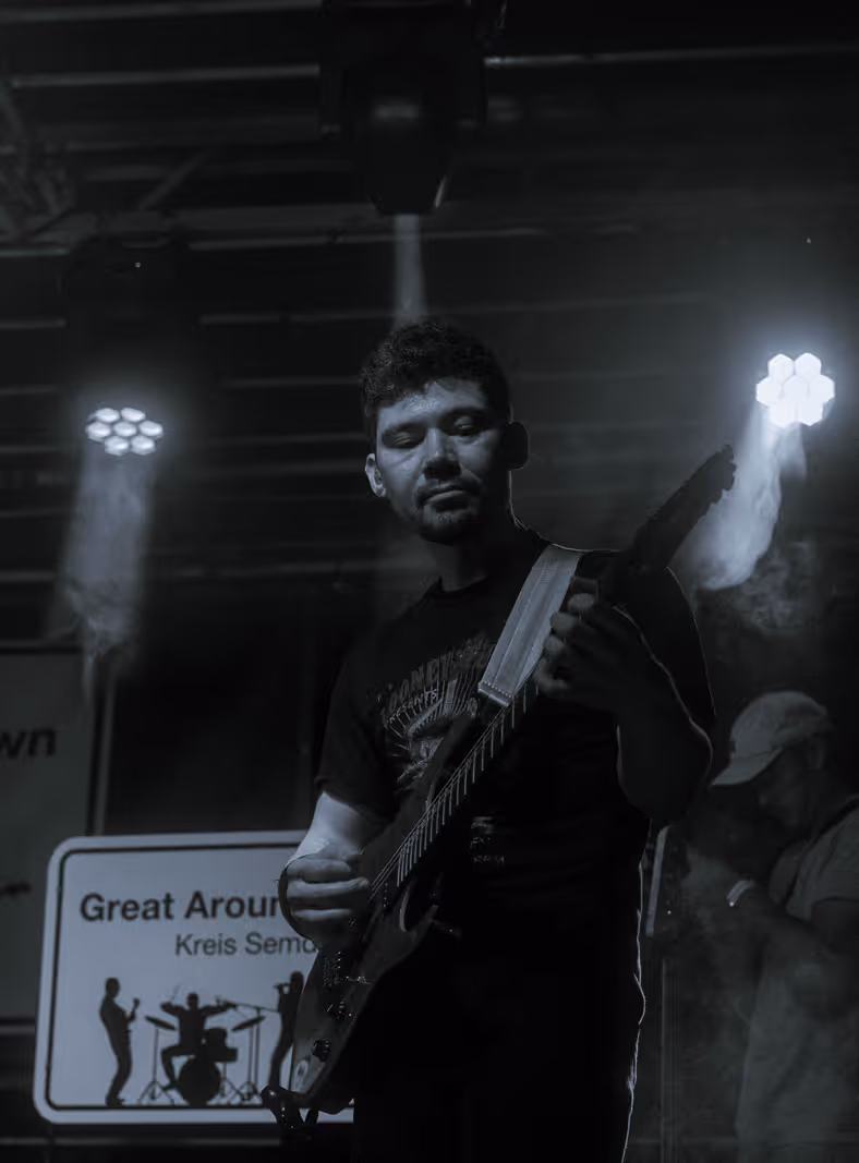 Gitarrist von Great Around Town spielt während des Schützenfest-Auftritts unter farbigen Scheinwerfern
