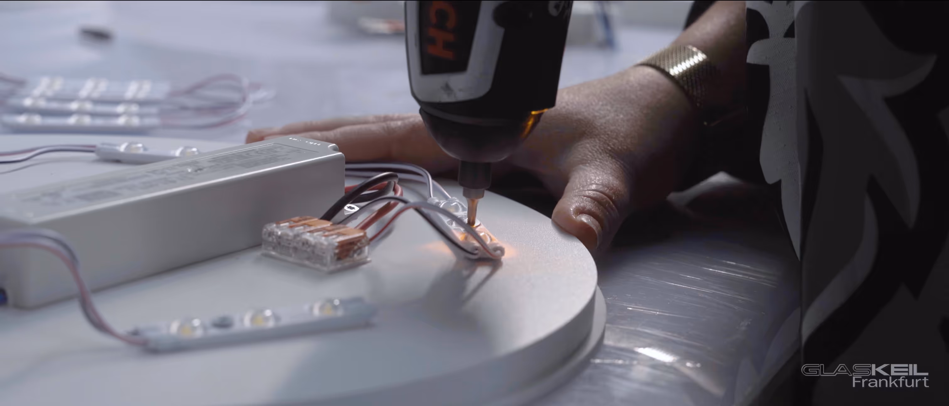 Nahaufnahme der Montage einer LED-Lampe mit Akkuschrauber – Produktion der GlasKeil x Löwen Frankfurt Fan-Lampe – Corporate Storytelling Video