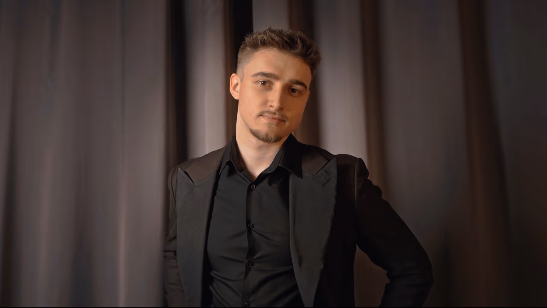 Professionelles Porträt von Michael Peskov im schwarzen Anzug vor dunklem Vorhang – Fokus auf Personal Branding und Premium-Look für seine neue Webpräsenz.