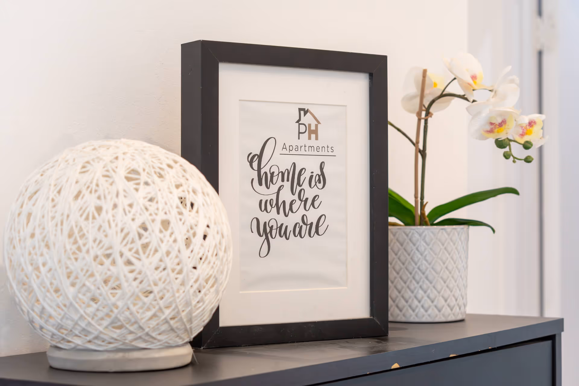 pormenor de decoração com moldura com mensagem "Home is where you are"