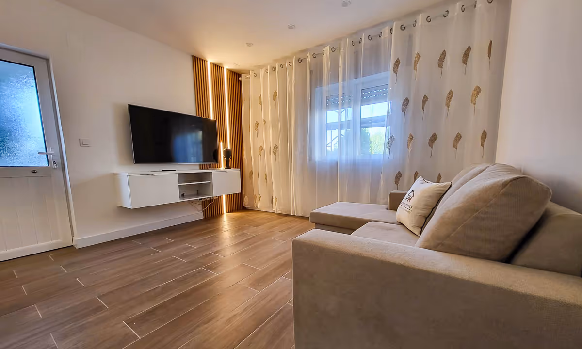 Sala de estar do apartamento Elegance I no Fundão com televisão e design contemporâneo
