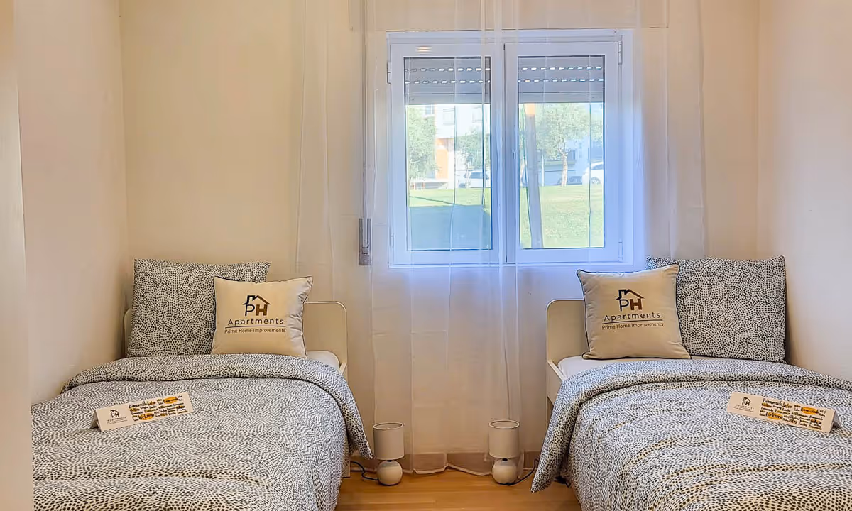 Quarto duplo do apartamento Elegance I com duas camas individuais e janelas amplas