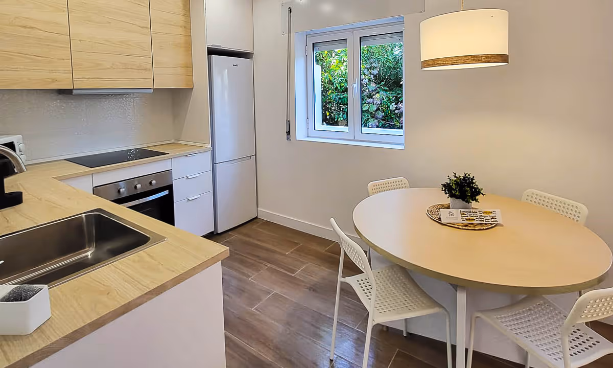 Cozinha equipada do apartamento Elegance I com eletrodomésticos modernos e vista para jardim