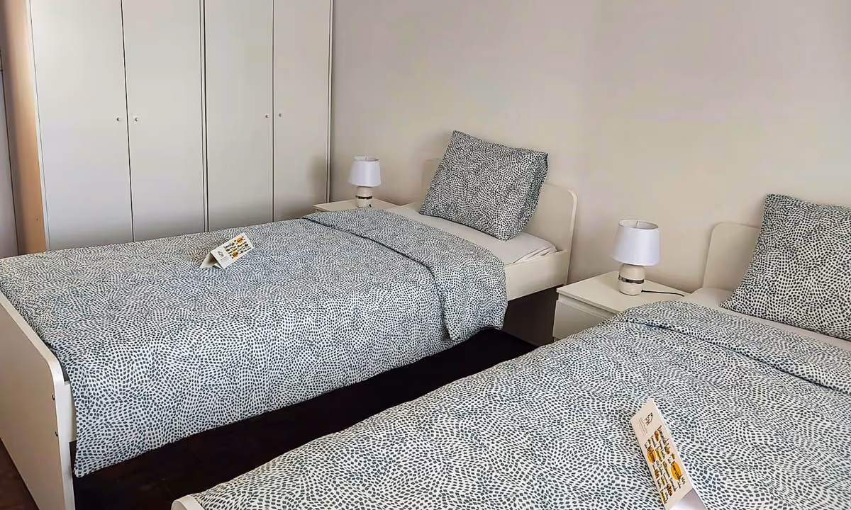 Quarto duplo do apartamento Snow I com camas individuais e roupa de cama azul clara