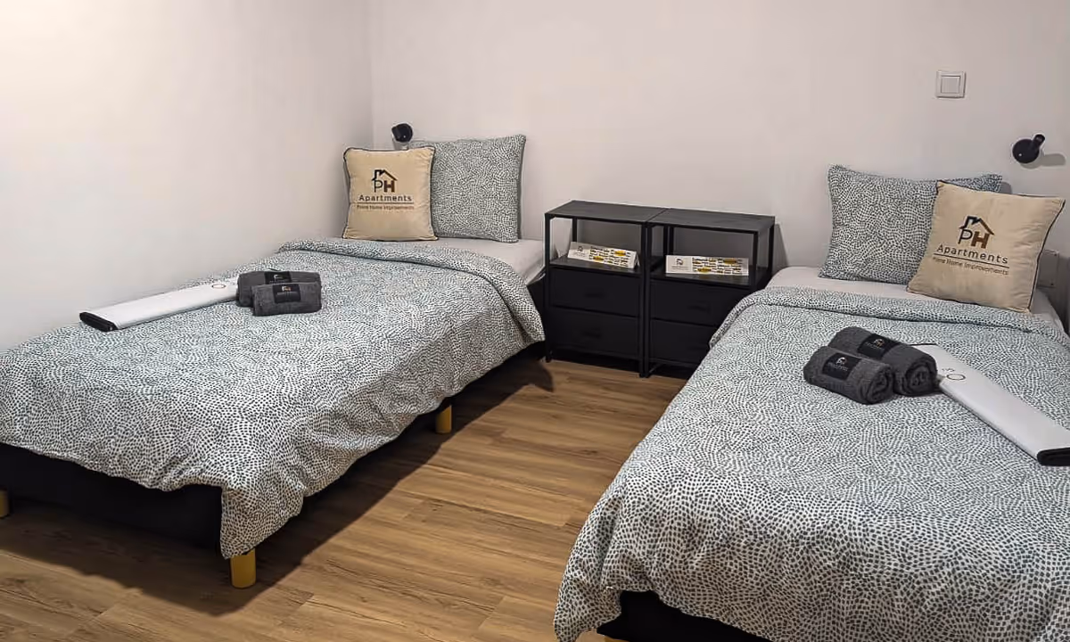 Quarto duplo do apartamento Gaia Prime II com almofadas PH Apartments e roupa de cama azul clara