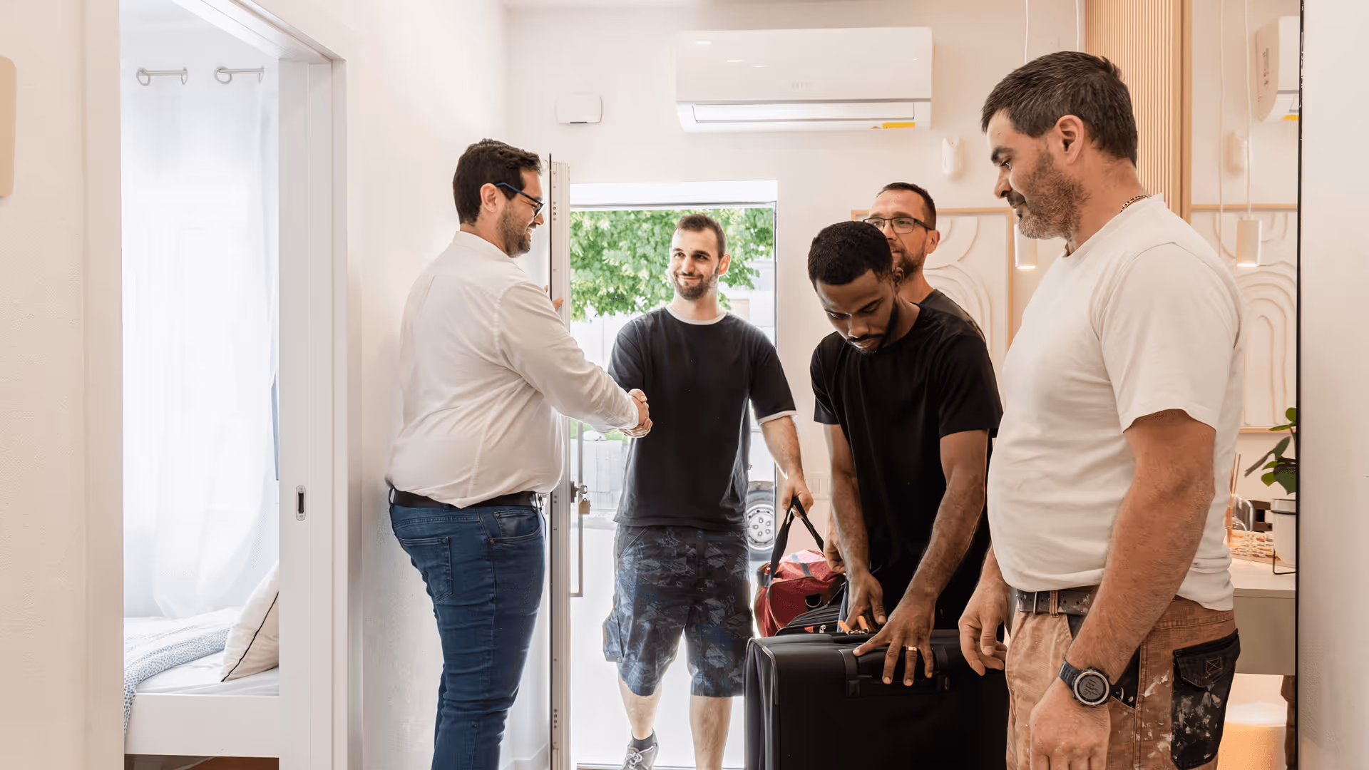 Grupo de colaboradores são recebidos pelo ceo da PH Apartments no apartamento onde vão ficar alojados temporariamente em contexto profissional