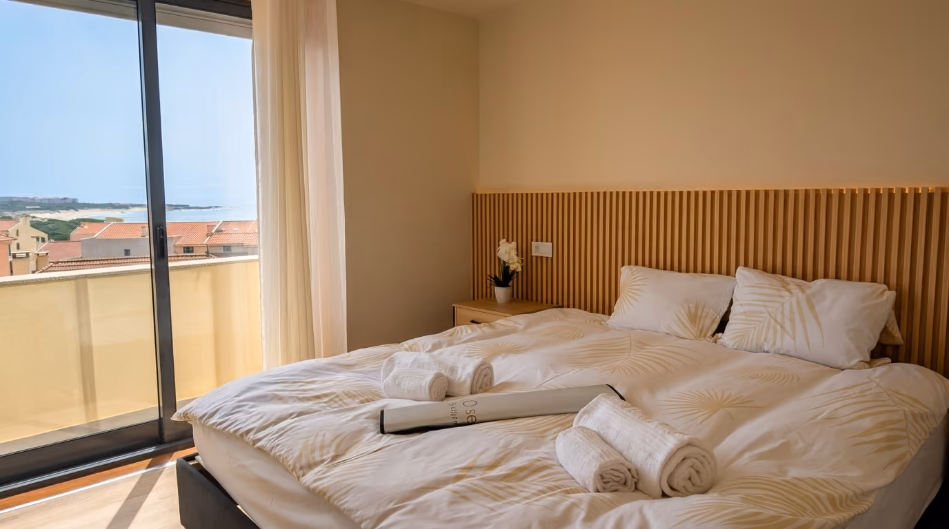 Quarto de casal amplo e luminoso com acesso à varanda e decoração em tons neutros no apartamento em Vila Praia de Âncora.