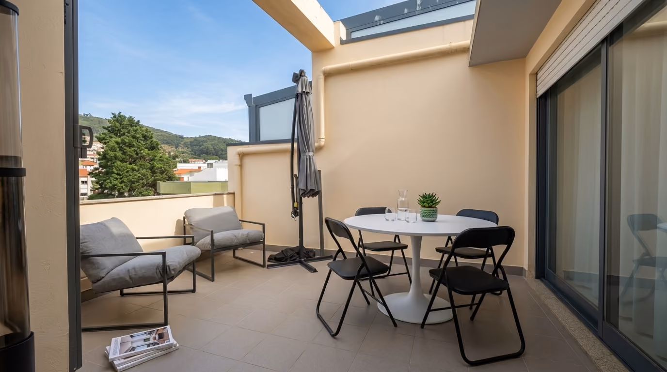 Varanda exterior mobilado do apartamento em Vila Praia de Âncora, com zona de refeições e vista para a envolvente.