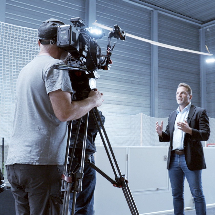 Glice CEO Viktor Meier is giving an Interview in an Ice Rink Hall in front of a professional camera crew.