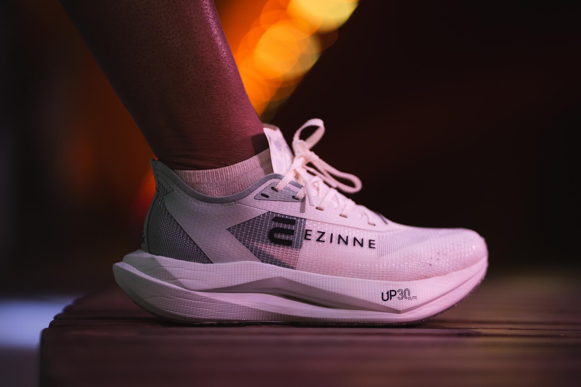 Hvite Ezinne-karbonløpesko. Toppmodell for asfaltløp og tredemølle. Bildet viser et nærbilde av skoene under en pause i løpeøkten i Fyllingsdalstunnelen, Bergen.