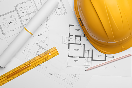 Construction blueprints with hard hat and ruler