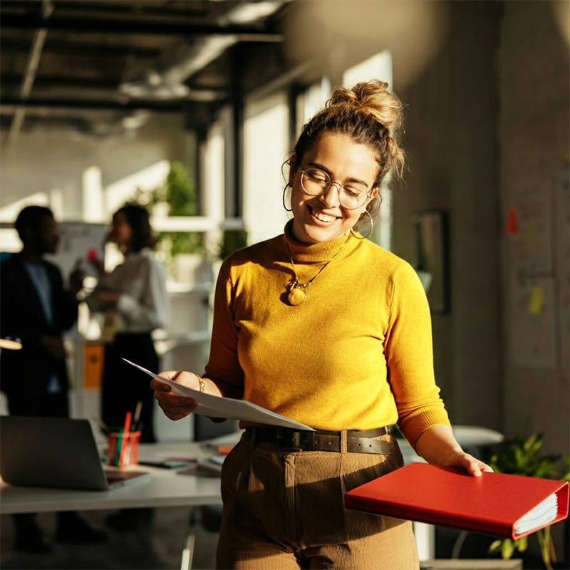 a lady in an office holding a folder