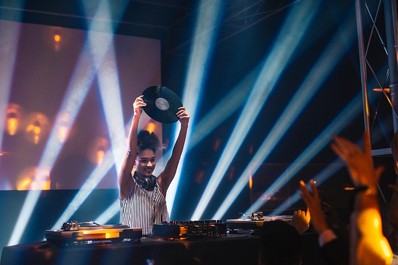 DJ at an event holding a record up to the crowd