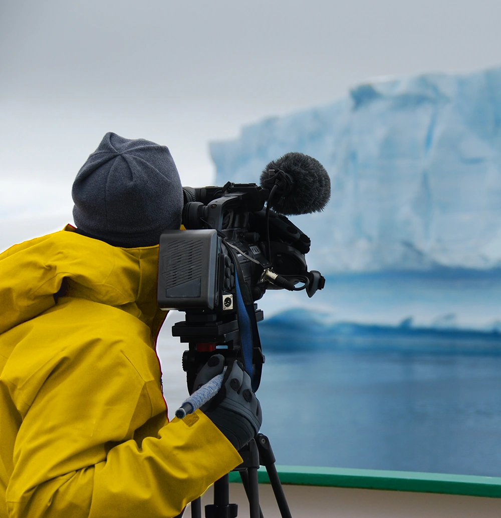 someone filming a large floating ice block