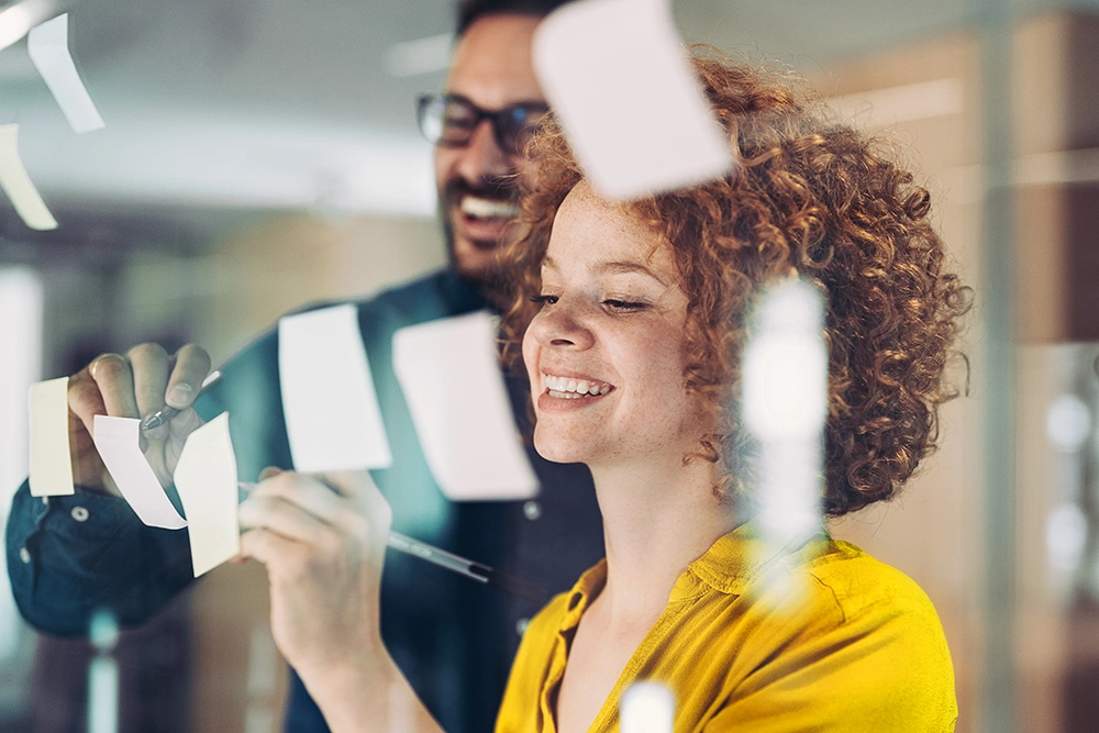2 people having a post-it note meeting