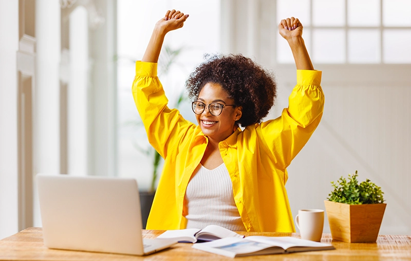Lady celebrating at laptop