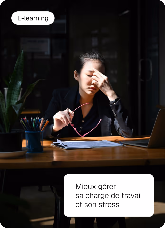a woman sitting at a desk with her hand on her eye