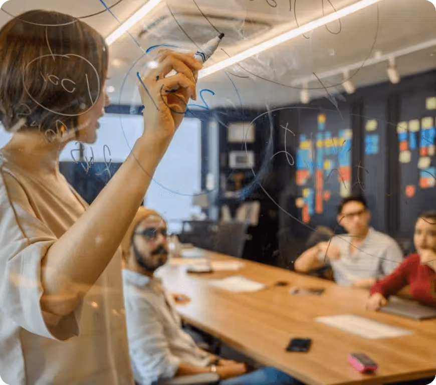 a woman writing on a glass board