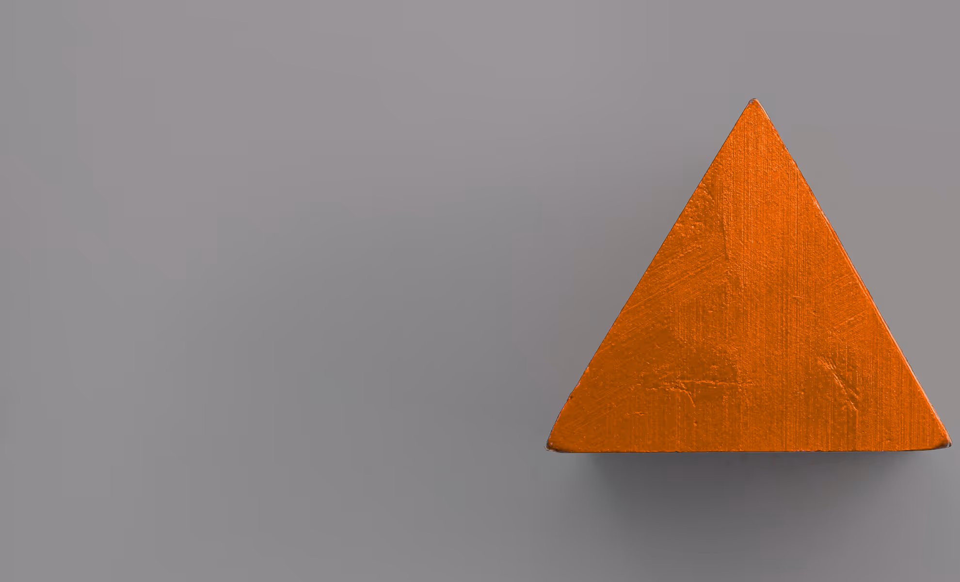 Oransje trekantet trekloss på en grå bakgrunn.