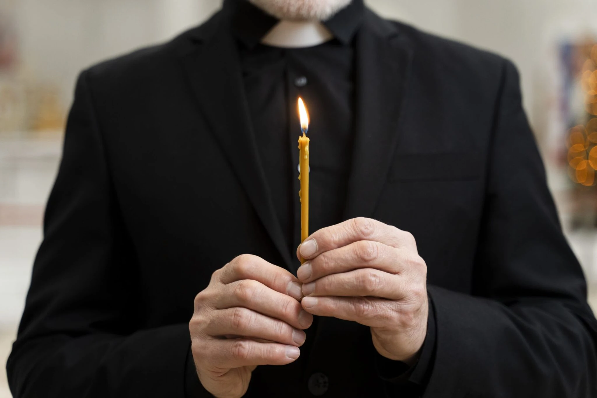 man in black with a candle in his hands