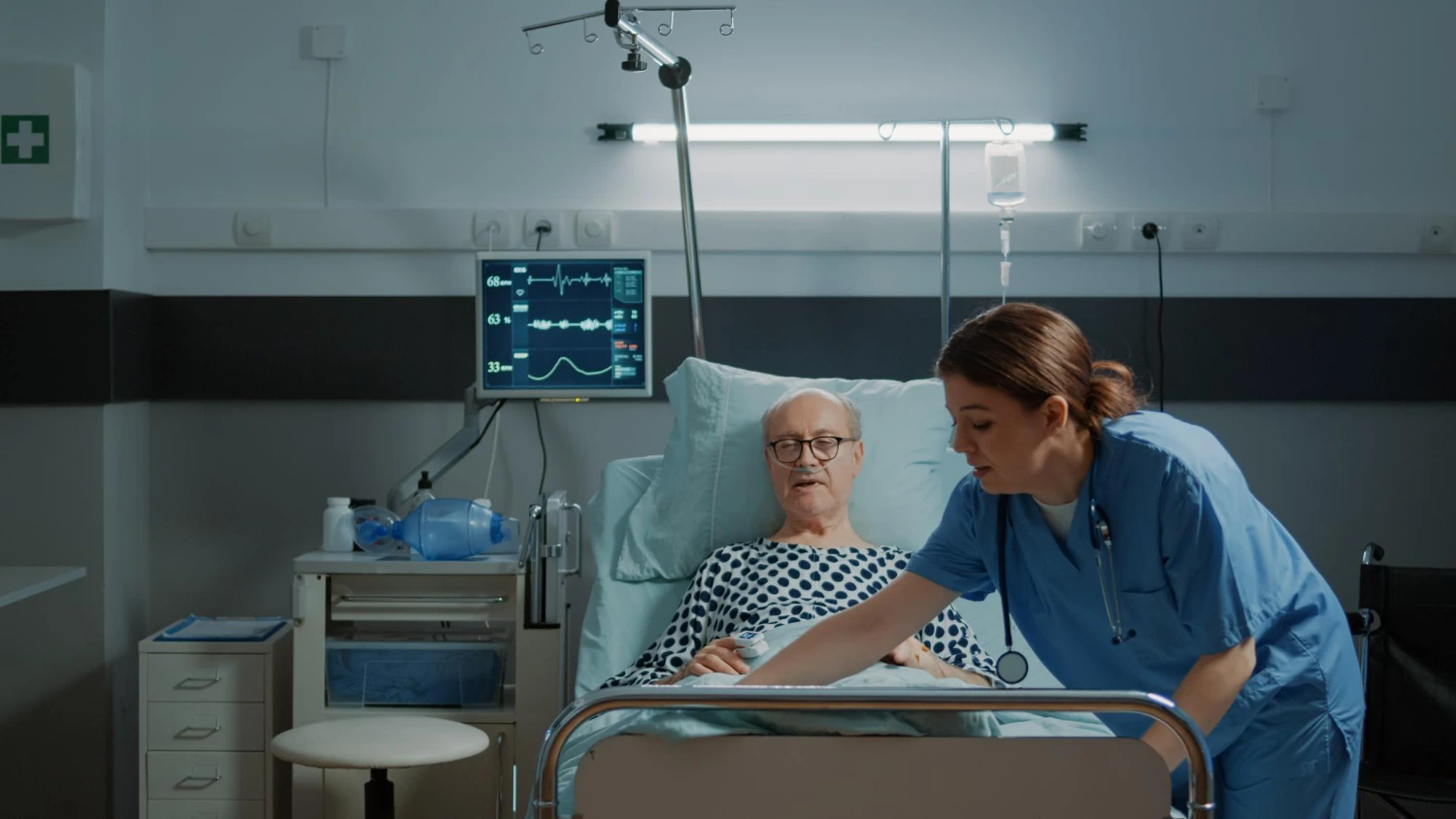 Nurse checking on elderly man in hospital ward