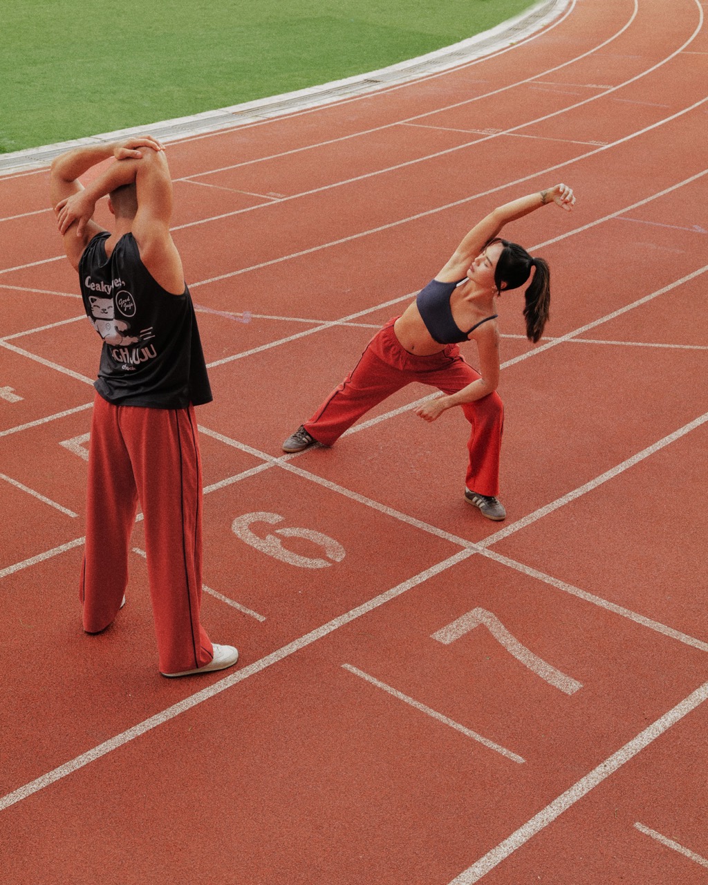 two people stretching in their Good Juju x Cheak merch
