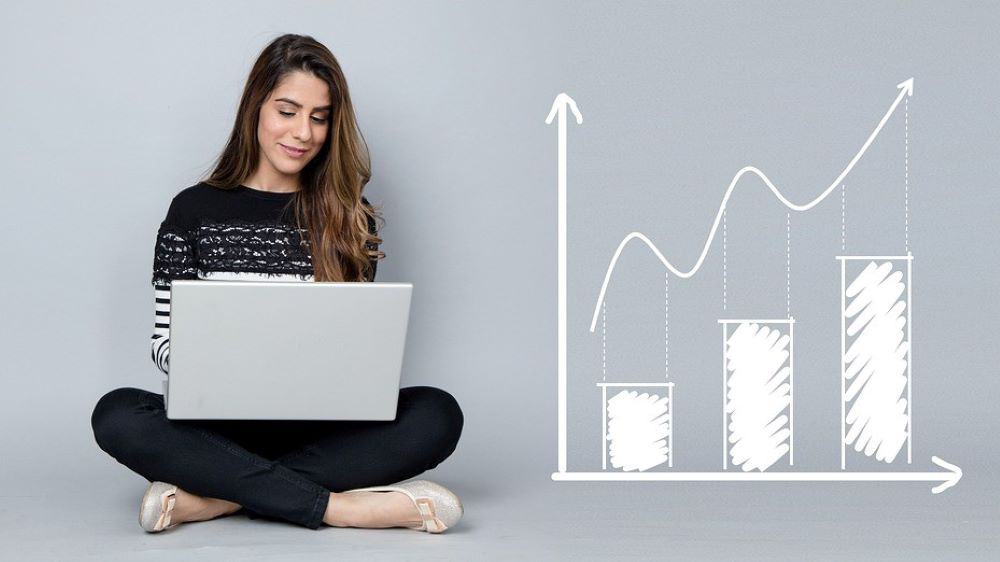 Amazon private label - lady sitting on the floor using a laptop beside a graph