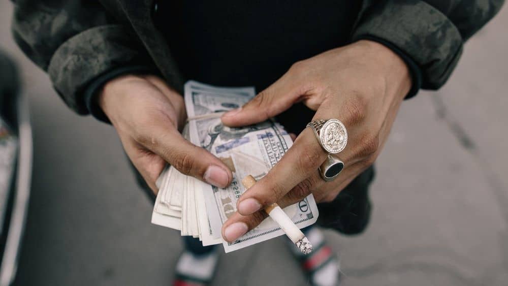 Cold cash in hand with cigarettes 
