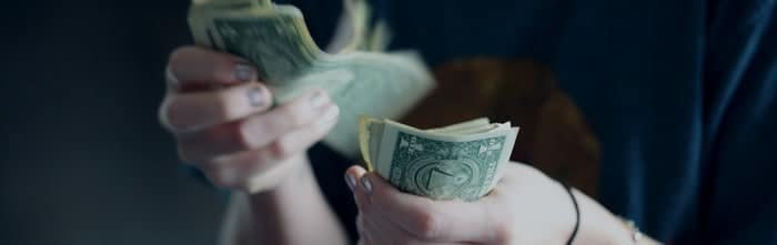 Person counting US dollar bills