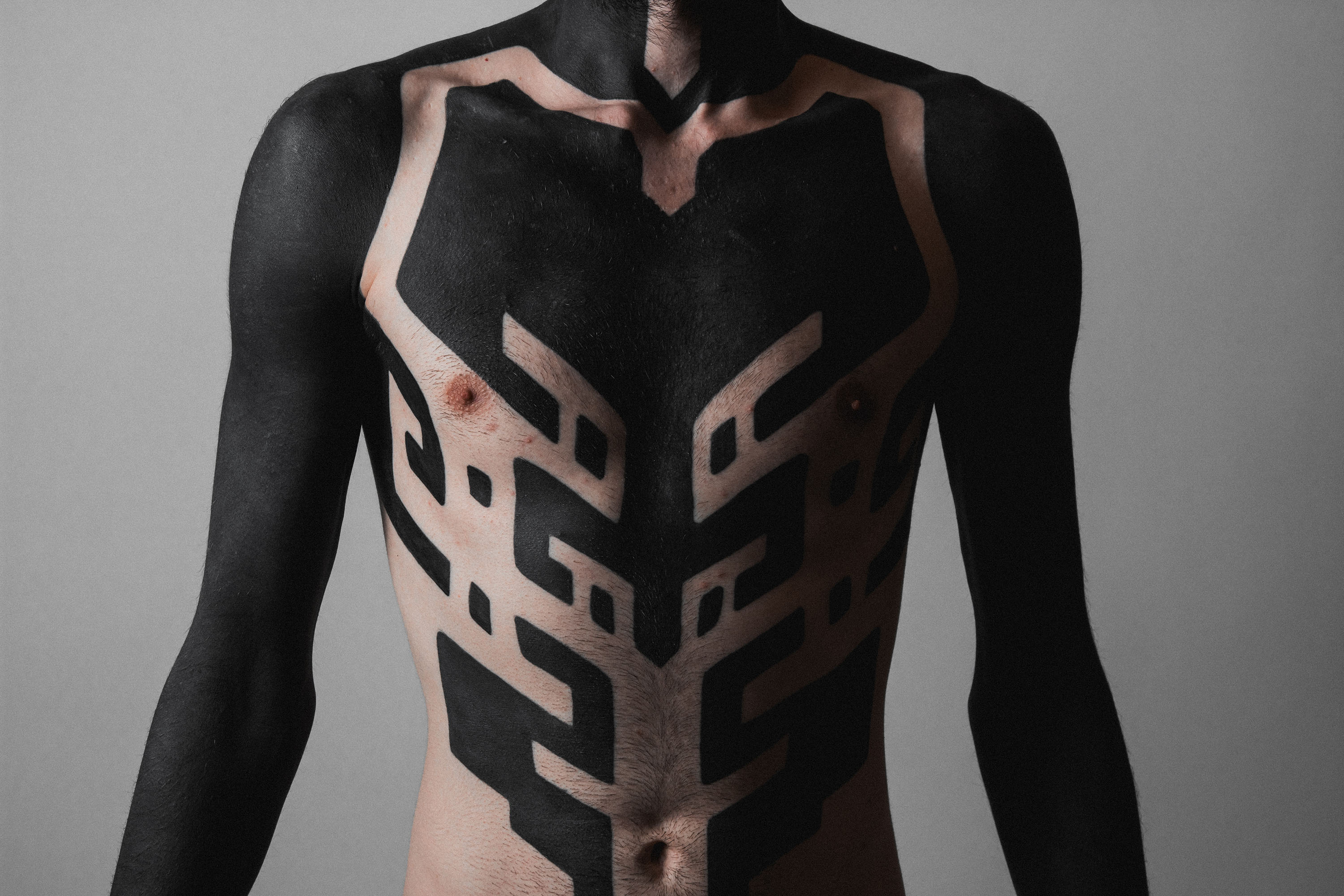 Powerful black tattoo depicting a roaring lion's head, capturing the essence of strength and courage with its finely shaded mane and fierce expression