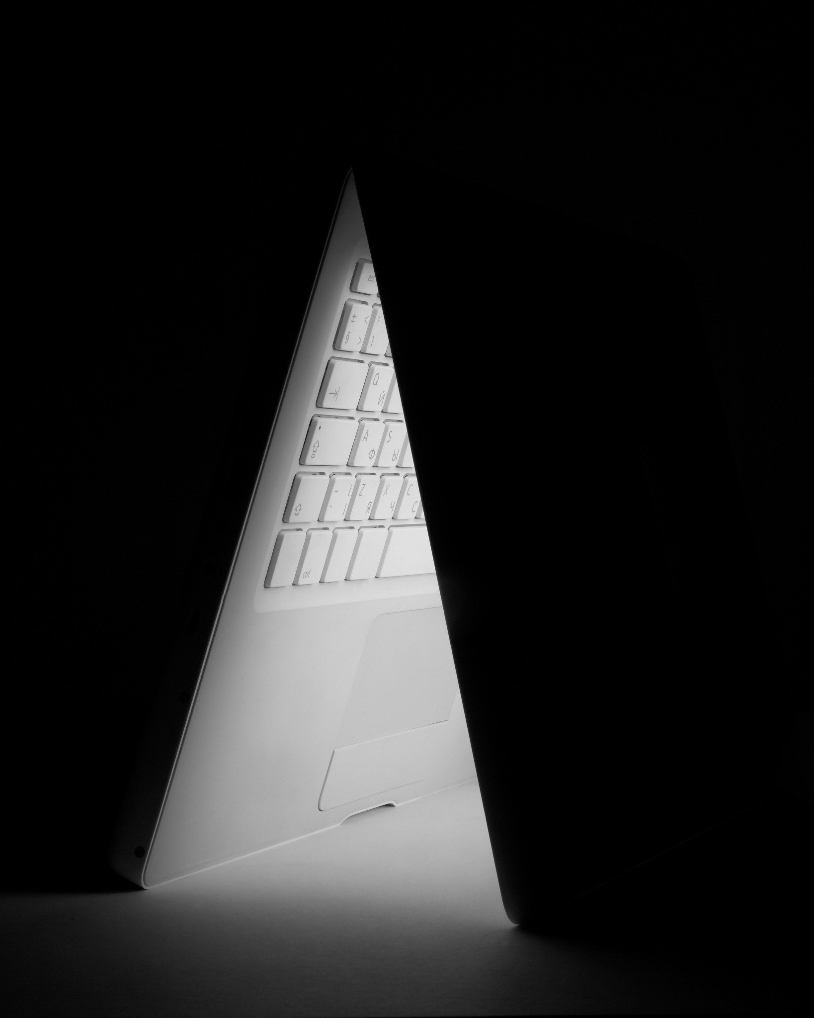 Teilweise geöffneter Laptop im Dunkeln, beleuchtet durch die Tastatur – steht für technische SEO-Optimierung und Kontrolle über Website-Struktur.