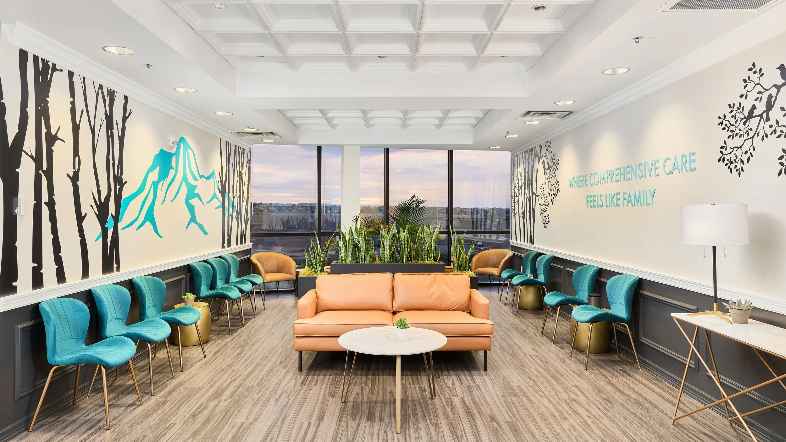 Medical office interior design with branded patient lounge, biophilic snake plant wall, teal contract seating, and spatial branding by Pasley Commercial Interiors, Colorado Springs.