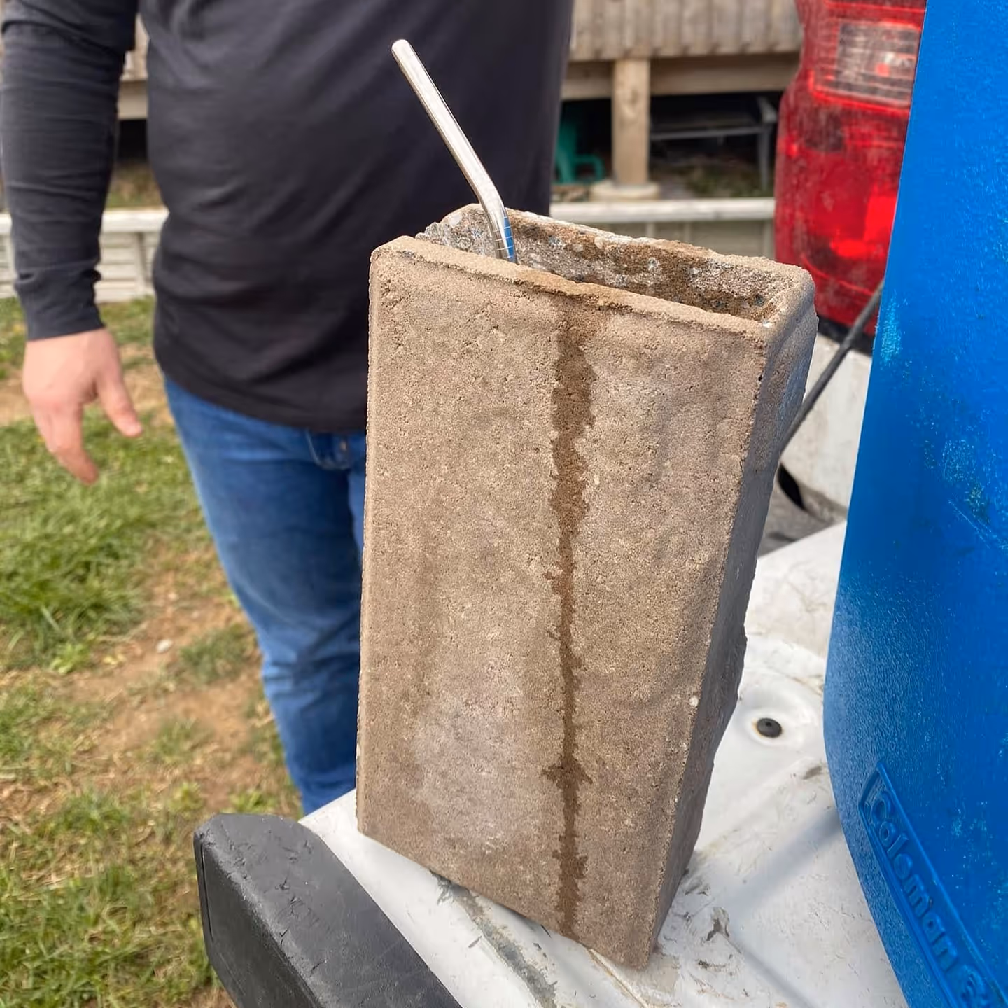 An image of a metal straw inside a patio paver
