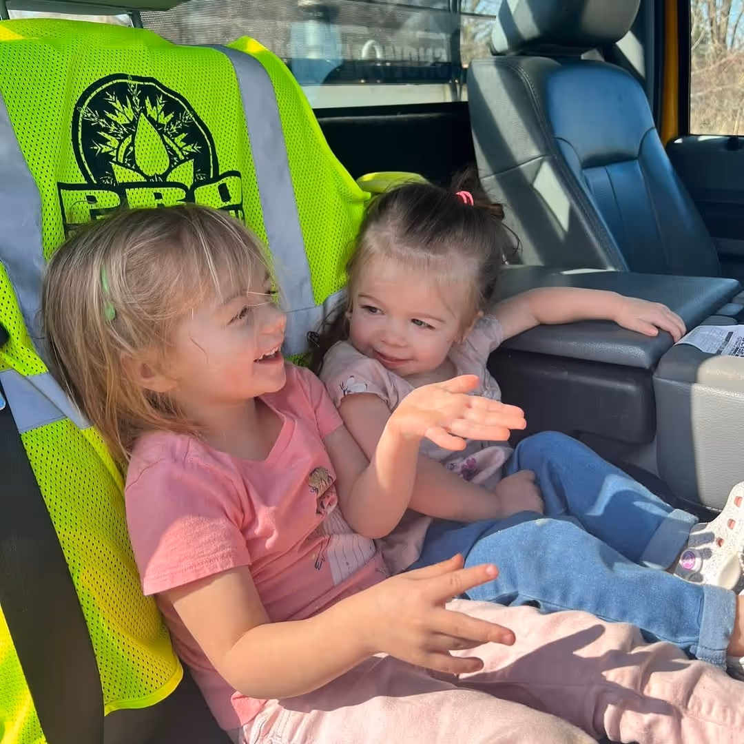 Two young kids sitting in the front seat of a truck, daughters of PSR owner Michael Johnson