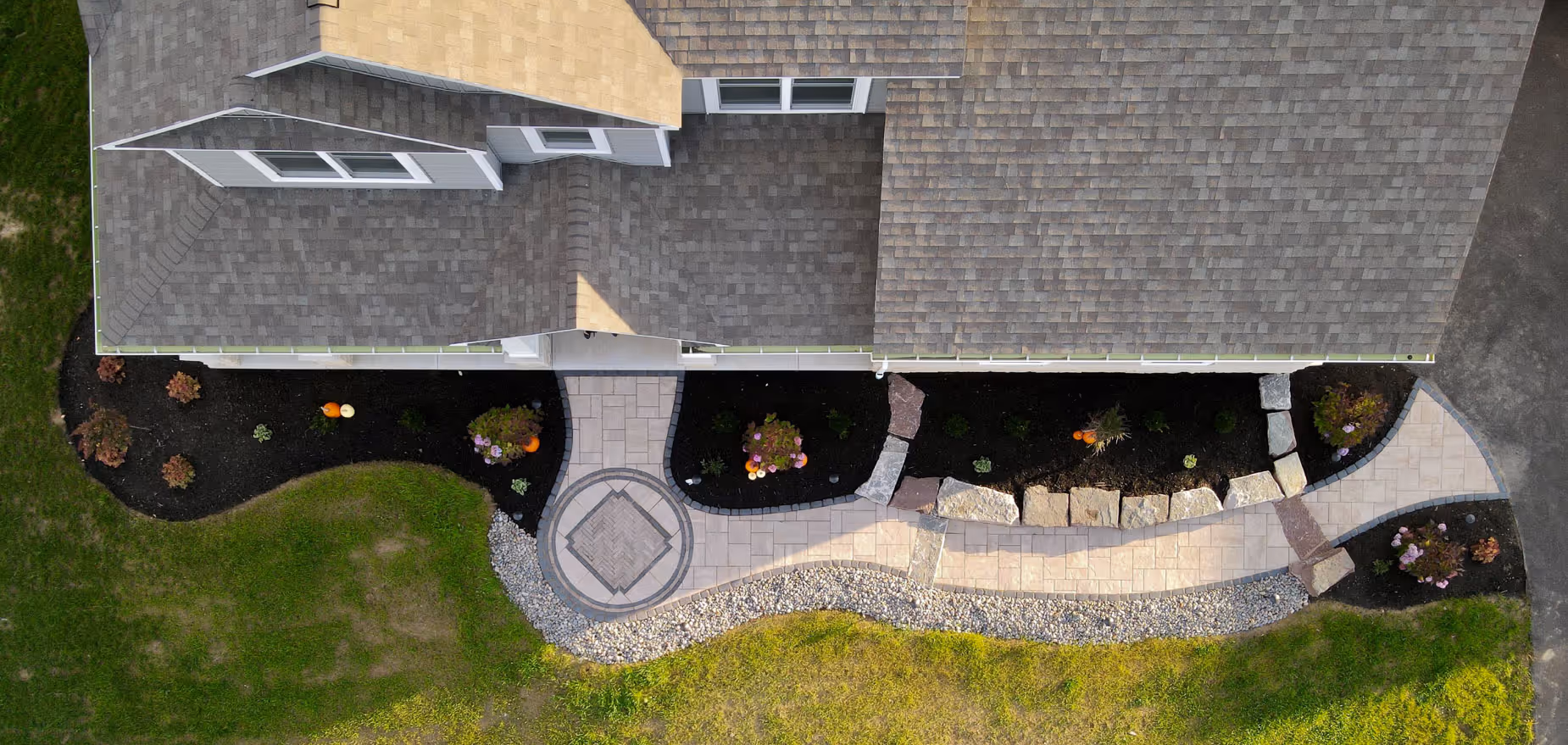 Front entryway in Syracuse with curved paver walkway and flower beds