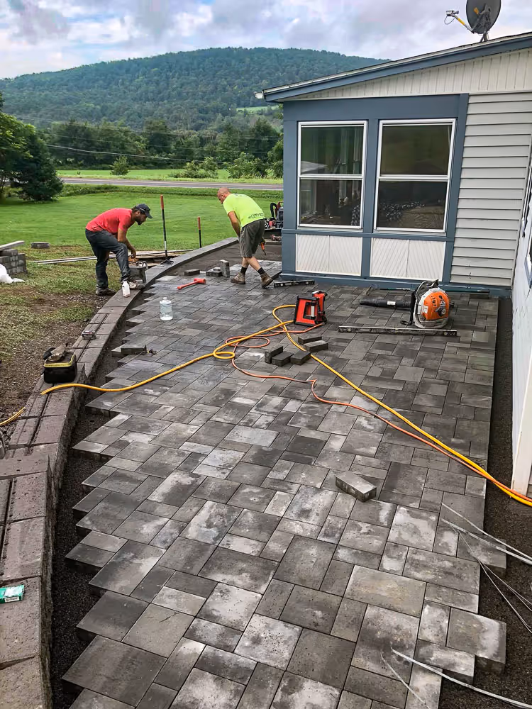 Curved patio being installed in Cortland, NY area with PSR workers onsite