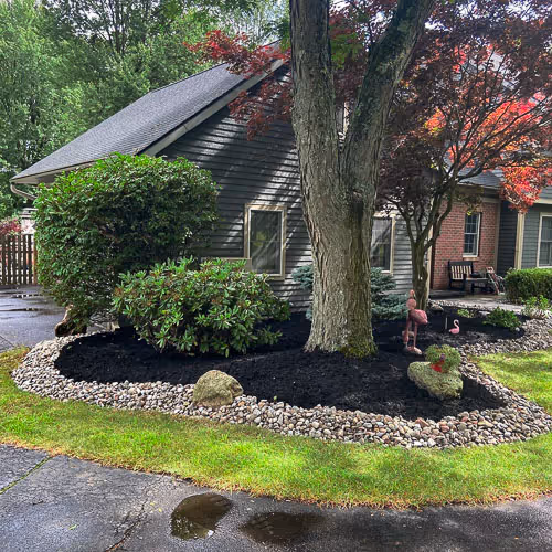 An ornate flower bed and trees installed by PSR outside a home in Whitesboro, NY