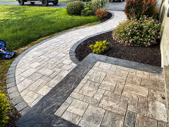Curved stone paver walkway installed by Pro Snow Removal in Syracuse, NY