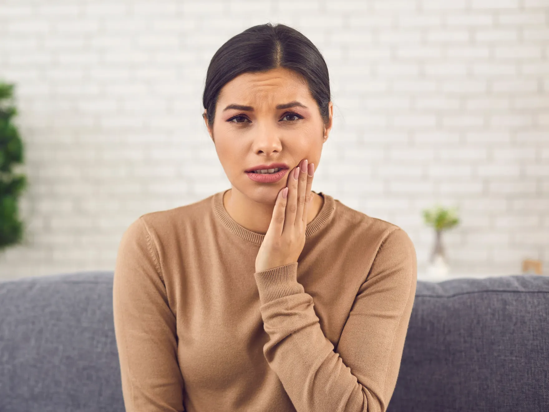 woman holding her cheek in pain