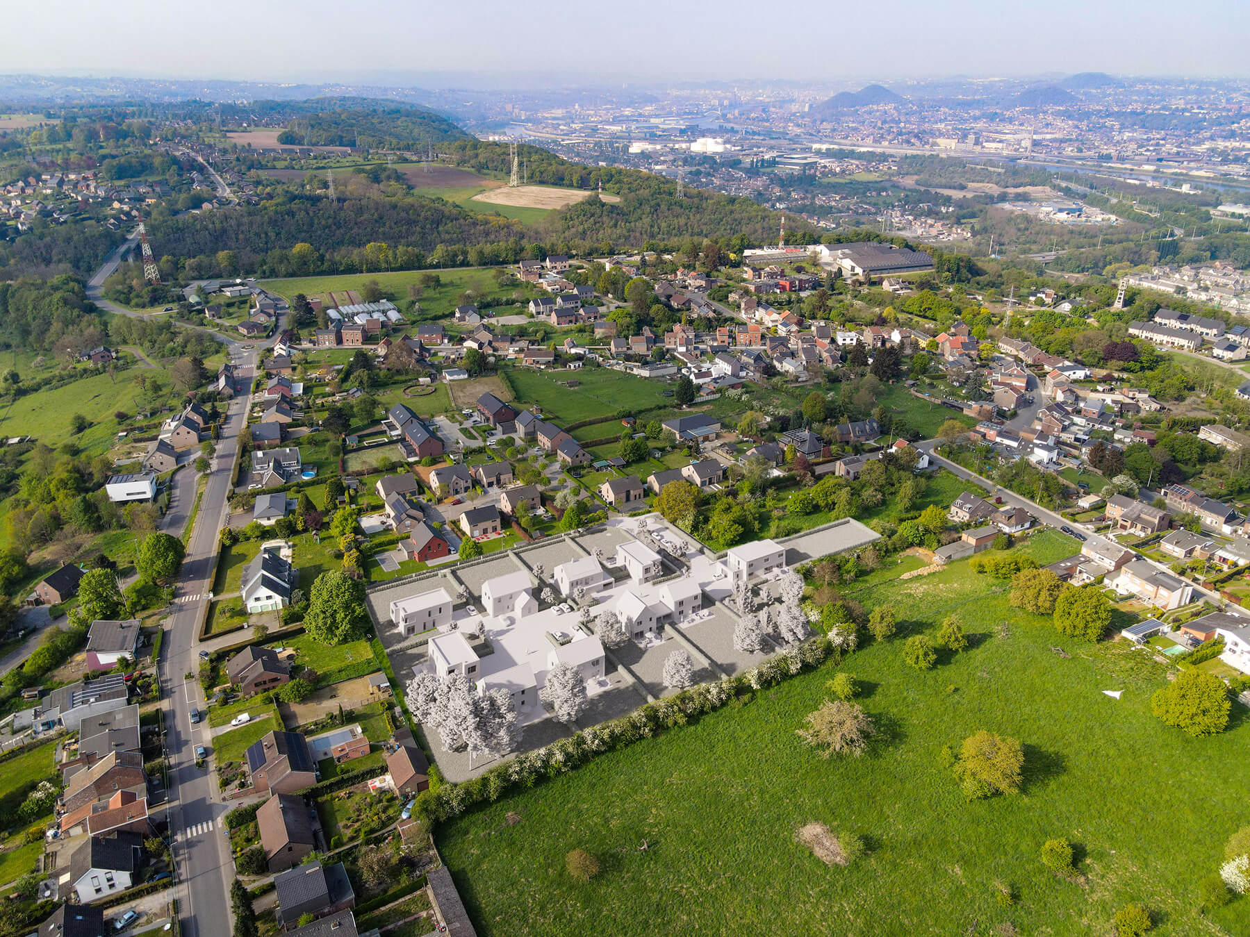 Vue aérienne du projet immobilier 'Clos des Arts' à Cheratte, illustrant l'intégration du lotissement neuf dans un cadre verdoyant et sa proximité avec la ville de Liège.