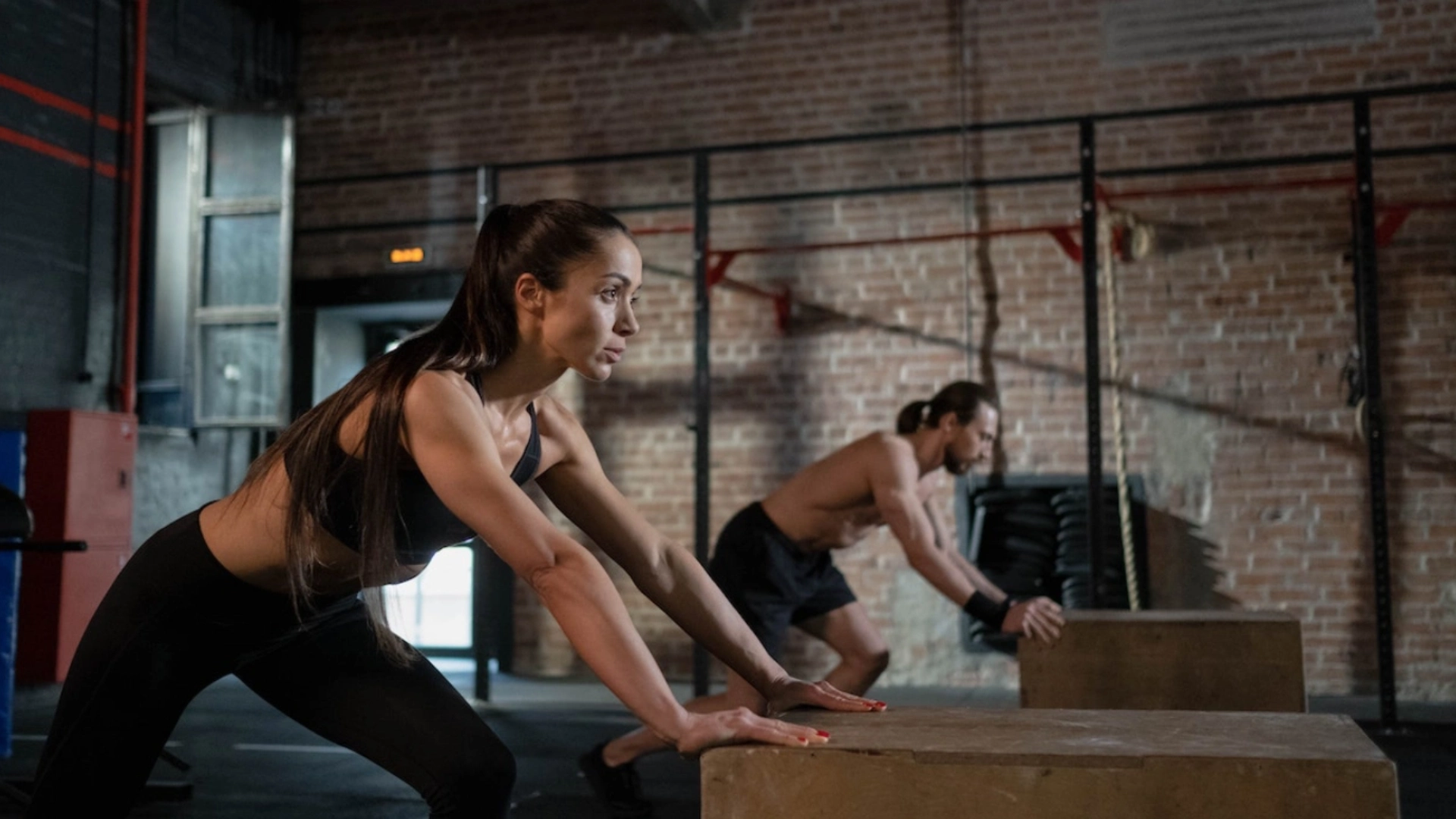 A man and woman perform push-ups on blocks in a gym at The CompoundCT, Inc. in Stamford, CT.