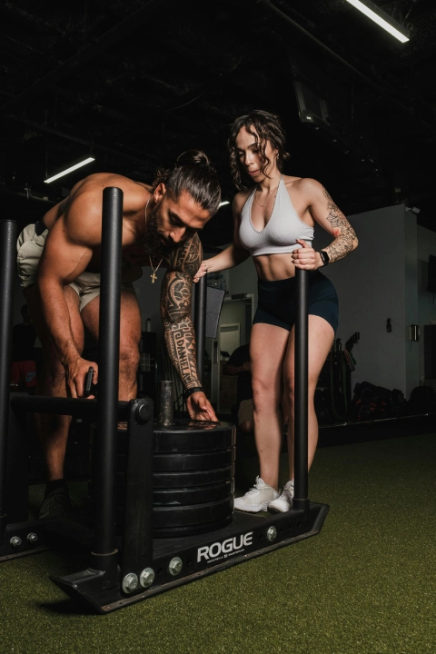 A man and woman perform push-ups in a gym during a personal training session in Stamford, CT.