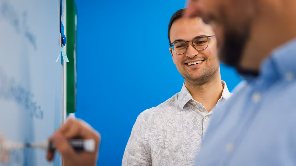 Team members brainstorming ideas at a whiteboard