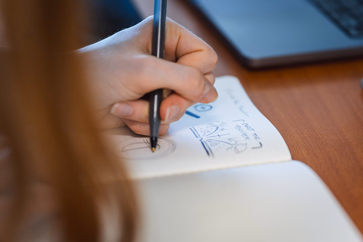 Team member sketching in a notebook