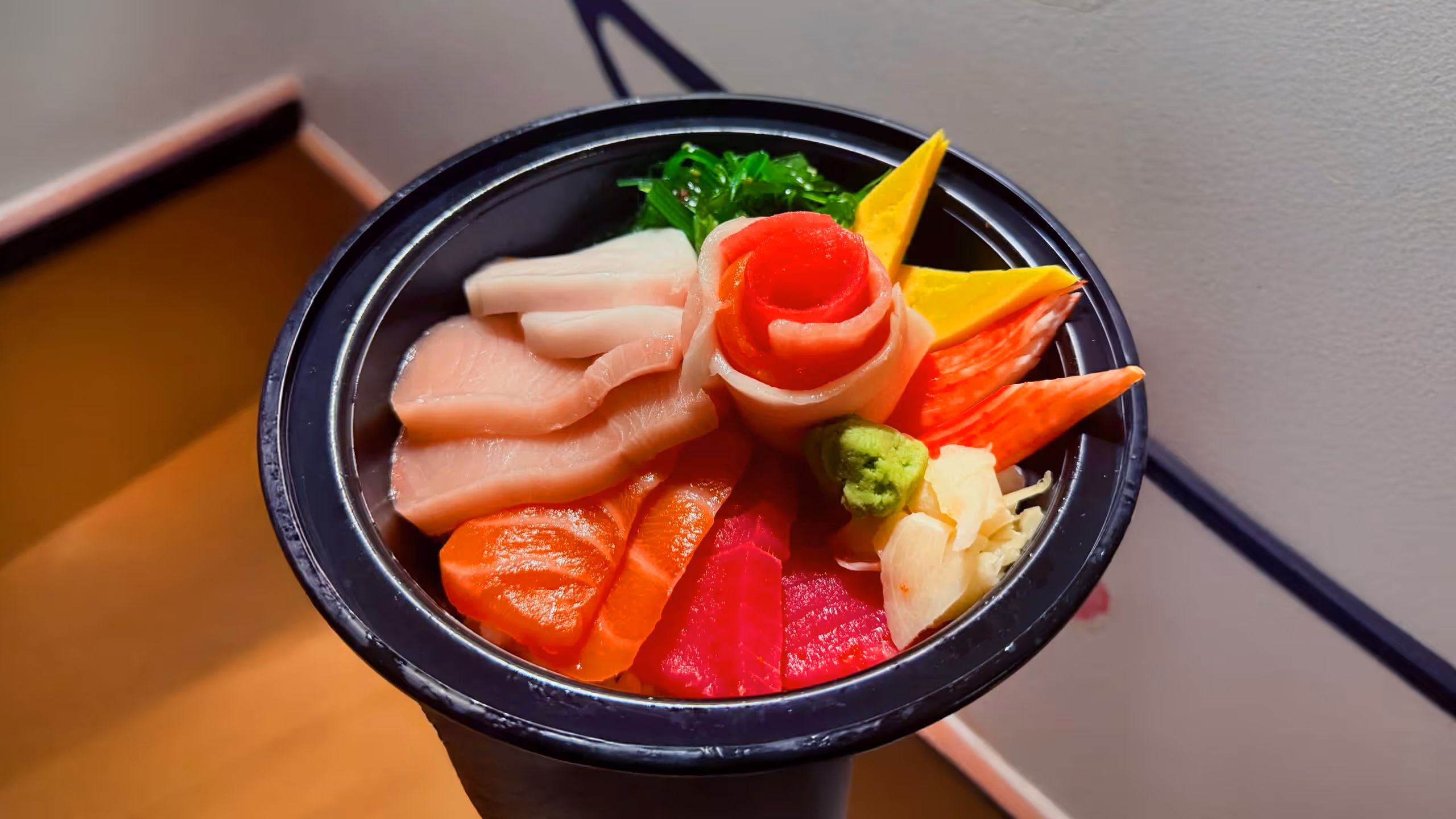 A bowl filled with different types of sashimi.